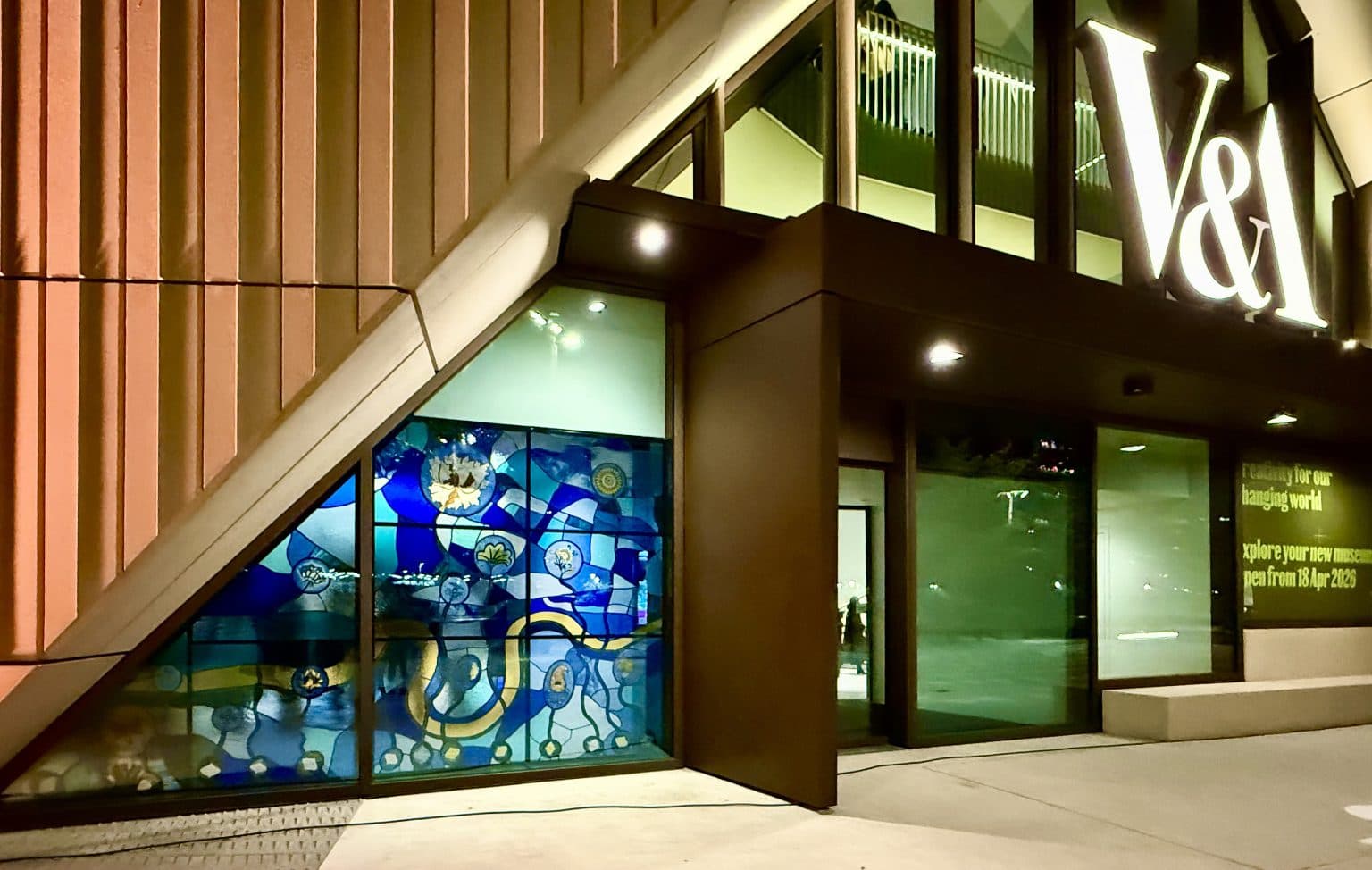 The illuminated stained-glass window beside the entrance to V&A East Museum