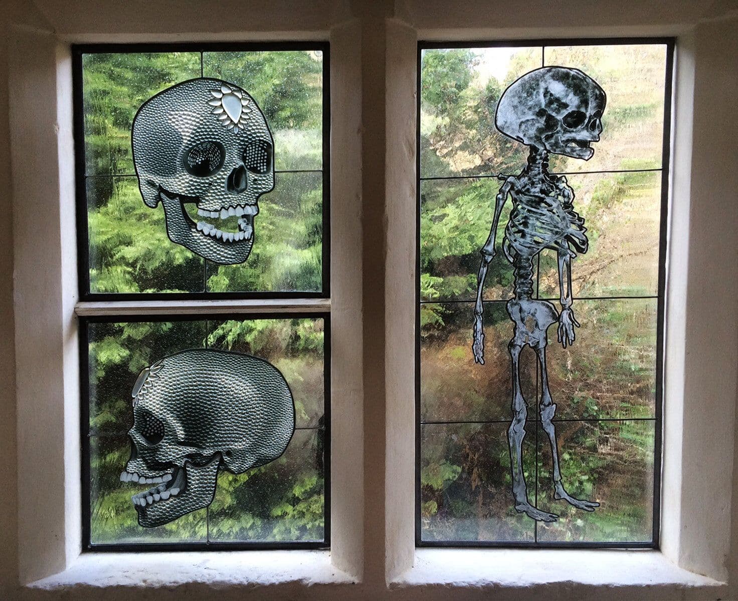 Installed stained-glass skull and skeleton windows commissioned by Damien Hirst